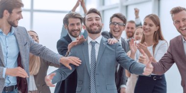 güler yüzlü bir iş ekibi önünde duran emin gururlu işadamı.