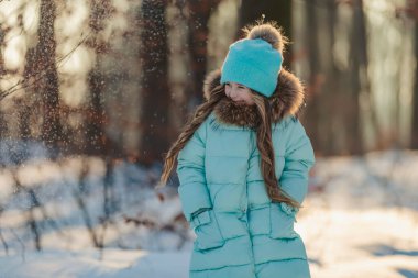 Turkuaz ceketli ve şapkalı kız.