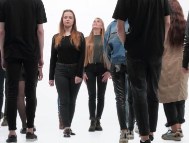 ciddi genç kadın ve erkek grupları birbirlerine doğru yürüyorlar.