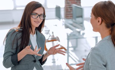 İki çalışan ofiste konuşurken.