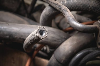 Rubber pipes and hoses leading from the car radiator to the engine, view of the engine from below. old worn rubber car cooling system hoses