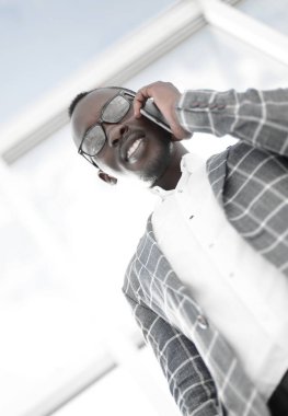 Alt manzara. Gülümseyen iş adamı cep telefonuyla konuşuyor