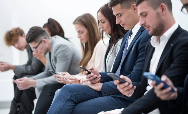 Νέοι Εργαζόμενοι Smartphones Που Κάθονται Στην Ίδια Σειρά — Φωτογραφία Αρχείου