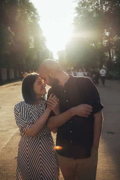 恋人たちは夏に公園を散歩します 少女はしっかりと男の手を握ってる 太陽のまぶしさ — ストック写真