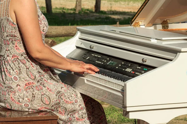 白い電気ピアノを演奏する女性 — ストック写真