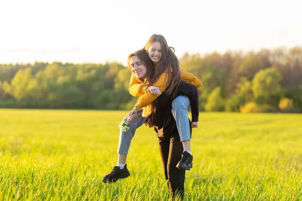 Playful Mother Giving Daughter Piggy Back Ride Green Field — Stock Photo, Image