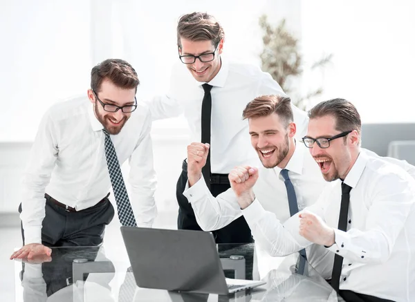 stock image triumphant business team looking at the laptop screen