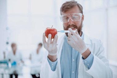 Laboratuvarda duran elma ve şırınga uzmanı.
