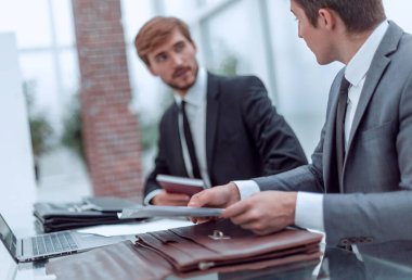 İş adamları büro masasında oturan belgeleri tartışıyor..