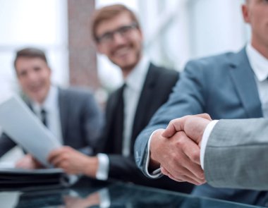 Ciddi bir iş adamı iş ortağıyla el sıkışıyor.