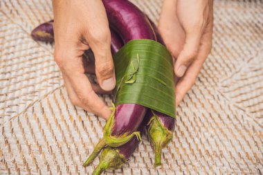 Çevre dostu ürün ambalaj konsepti. Patlıcan bir muz yaprağı sarılmış, plastik bir torba alternatif olarak. Sıfır atık kavramı. Alternatif ambalaj