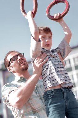Baba oğlu bar yetişmek için yardımcı olur.