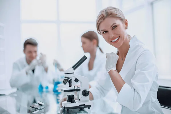 Odnosząca Sukcesy Kobieta Naukowiec Siedzi Przed Mikroskopem — Zdjęcie stockowe