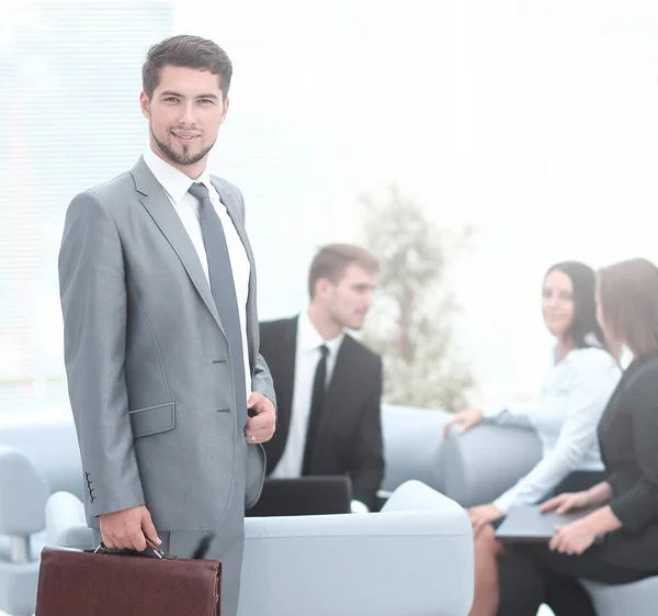 confident businessman with briefcase standing in the lobby of the office.