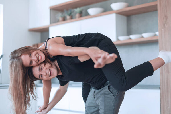 Счастливая молодая пара веселится на кухне
