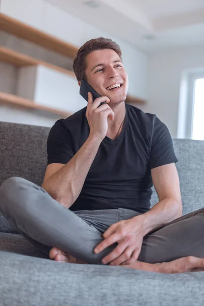 Yakışıklı Adam Oturma Odasında Akıllı Telefonuyla Konuşuyor — Stok fotoğraf