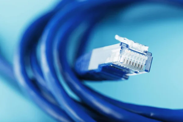 青い背景にデータ伝送のためのインターネットネットワークケーブルのコイル — ストック写真