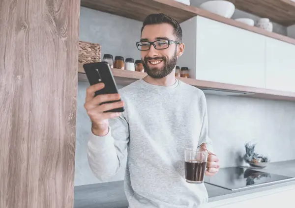 Homem Sorridente Com Smartphone Xícara Café Sua Cozinha — Fotografia de Stock