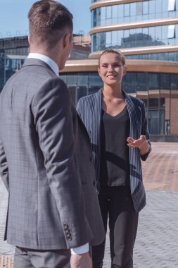 Genç iş adamları ofisin önünde konuşuyorlar.