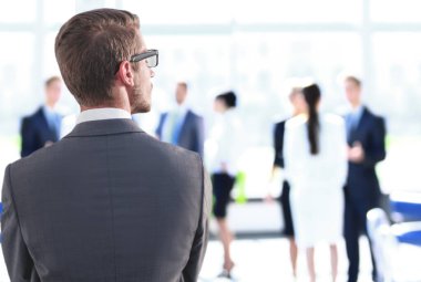 Ofis penceresinin yanında duran iş adamı.