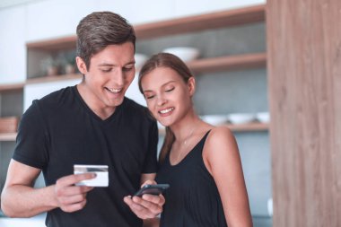 Genç çift online alışveriş için akıllı telefon kullanıyor..