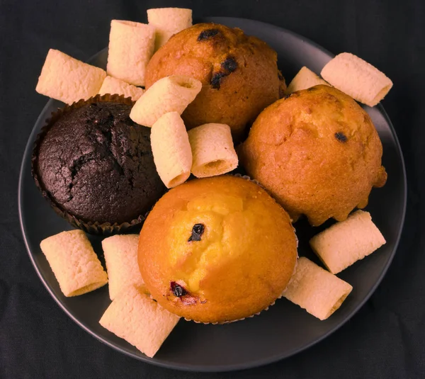 黒のプレートと黒の背景にカップケーキとポップコーン — ストック写真