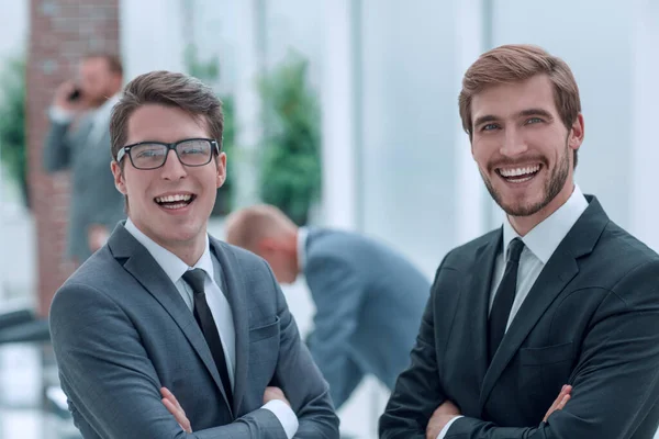 2人の幸せなビジネスマンがオフィスに立っていて — ストック写真