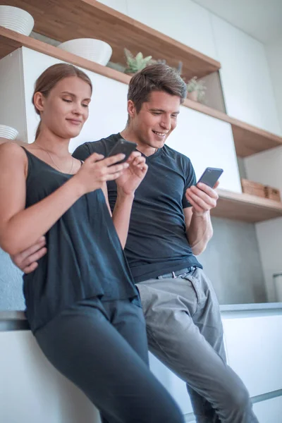 年轻貌美的夫妻在智能手机上看通信 — 图库照片
