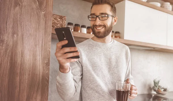 Homem Sorridente Com Smartphone Xícara Café Sua Cozinha — Fotografia de Stock