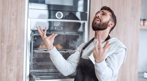 焼かれたクロワッサンと一緒にオーブンの近くに立つ驚くべき男 — ストック写真