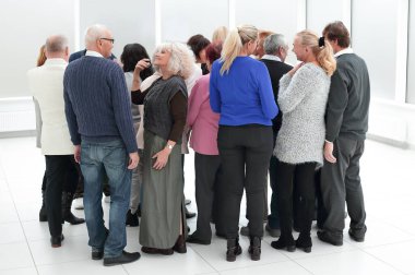 Bir grup yaşlı insan içeride sırtüstü duruyor.