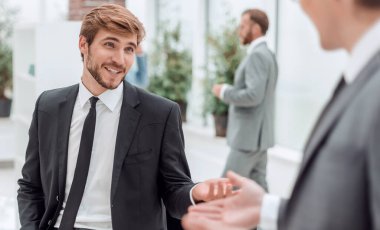 Çalışanlar fikirlerini ofis lobisinde tartışırlar.