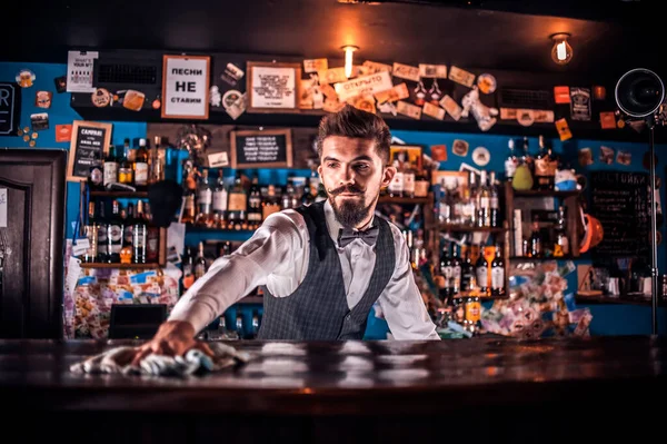 酒吧间服务员站在酒吧间柜台旁边时 酒吧间的特点是在鸡尾酒中添加配料 — 图库照片