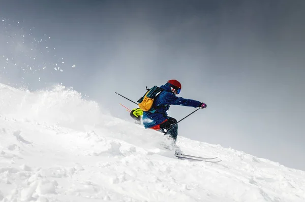 Kayakçı Kayakçı Oynak Arkasında Kar Bulutu Olan Karlı Bir Yamaçta — Stok fotoğraf