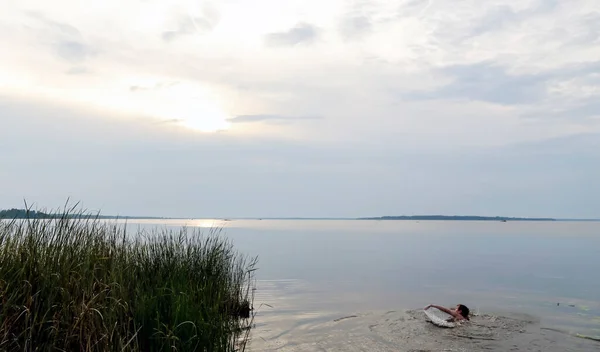 日没時に湖で若い男が入浴 — ストック写真