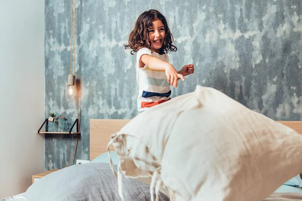 Funny Little Girl Bed Throwing Cushion —  Fotos de Stock