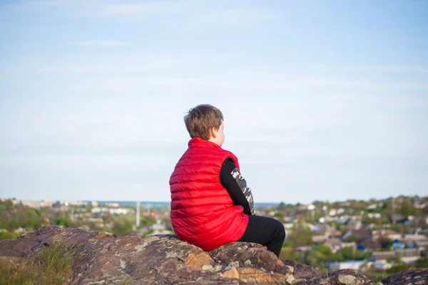 子供は崖の上に座って 下で何が起こっているかを見ています 岩の多い山の頂上からのパノラマビュー ロシア ロストフ地方 スケベラタヤ スカラ ドン世界の第7の不思議 — ストック写真