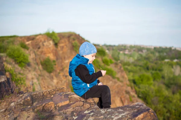 子供は崖の上に座って 下で何が起こっているかを見ています 岩の多い山の頂上からのパノラマビュー ロシア ロストフ地方 スケベラタヤ スカラ ドン世界の第7の不思議 — ストック写真