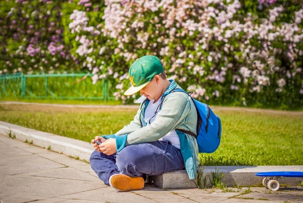 Young Man Sitting Side Lilac Alley Looking His Phone Background —  Fotos de Stock