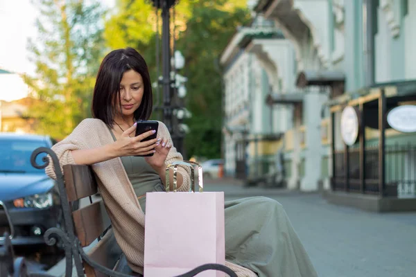 Νεαρή Όμορφη Γυναίκα Χαμογελώντας Πηγαίνει Στα Καταστήματα Χρησιμοποιώντας Smartphone — Φωτογραφία Αρχείου