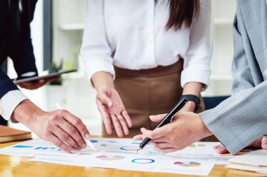 Yatırım risklerini azaltmayı planlayan bir grup iş adamının ortaklarla birlikte çalıştığı imajı, toplantılarda kârlı ve hedeflenmiş müşteri ihtiyaçlarını analiz etmek üzere pazarlama stratejilerini ayarlıyor