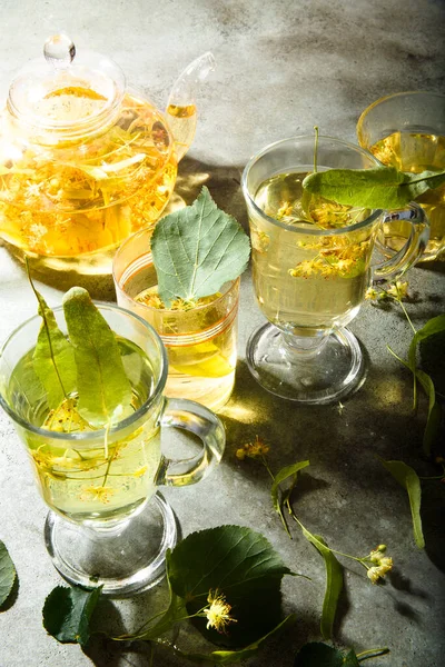 Glasses Freshly Made Linden Tea Teapot Green Table Leaves Flowers — Stok fotoğraf