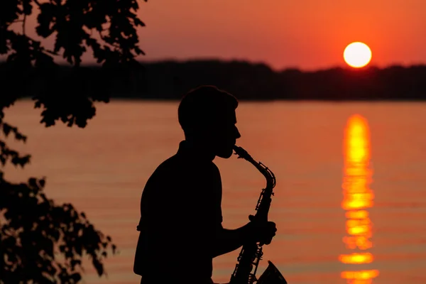 Silueta Mladého Muže Hrajícího Saxofon Večer Při Západu Slunce — Stock fotografie