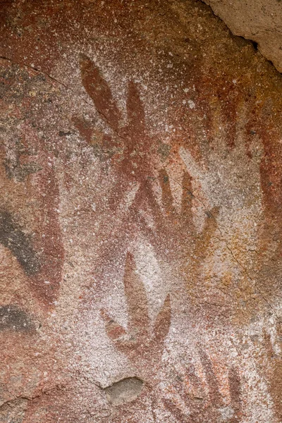 Human hands and guanaco paw. Cave of Hands, Patagonia Argentina. Ancient rock art.