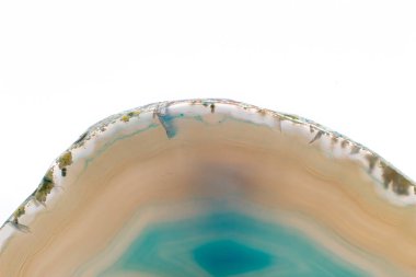 White and light Blue semi-transparent agate slice crystal, banded chalcedony stone isolated on a white background surface. Abstract light crystal image with lots of copy space