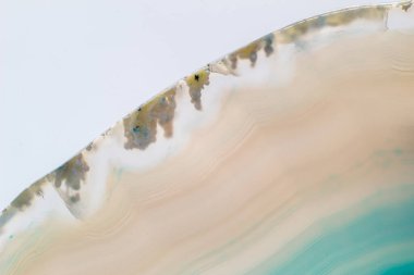 White and light Blue semi-transparent agate slice crystal, banded chalcedony stone isolated on a white background surface. Abstract light crystal image with lots of copy space