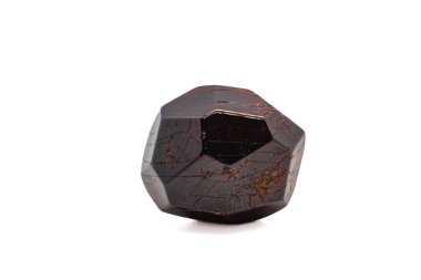 Dodecahedral doğal koyu kırmızı taş hafifçe yuvarlanmış cilalanmış kristal beyaz yüzey arka plan makro fotoğrafında izole edilmiş.