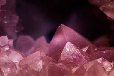 Macro focused vibrant pink amethyst quartz geode crystal, rose hematite amethyst points isolated on a white background surface