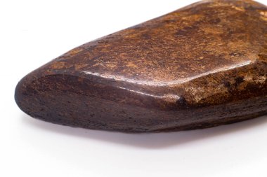 Macro Focused Tumbled Dark brown and shiny bronze bronzite stone polished crystal isolated on a white surface background 