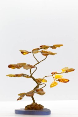 Canlı sarı ve turuncu cilalı kehribar kristal ve bakır tel ağaç beyaz yüzeyde izole edilmiş mavi kalsiyum mineral bazlı makro.